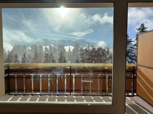 desde la ventana de un balcón con vistas a las montañas en Hotel Belmont, en Crans-Montana