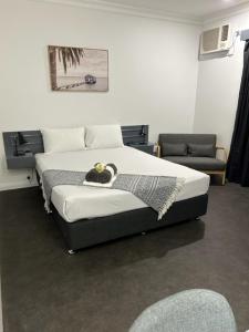 科夫斯港Country 2 Coast Motor Inn Coffs Harbour的一间卧室配有一张床和一把椅子