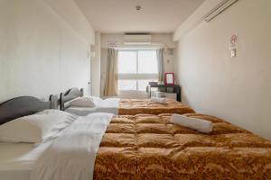 1 dormitorio con 2 camas y ventana en Fukuoka Share Hotel, en Fukuoka