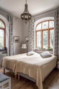 a bedroom with a large bed and two windows at Vita Huset på Österlen in Gärsnäs