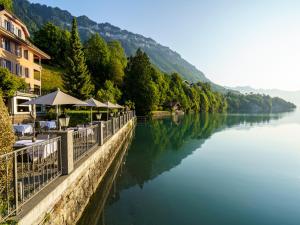 un fiume con tavoli e ombrelloni accanto a un edificio di Hotel Seeburg - Adults only a Ringgenberg