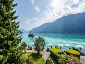 una barca su un lago con montagne sullo sfondo di Hotel Seeburg - Adults only a Ringgenberg