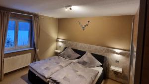 una camera da letto con letto, lenzuola e cuscini bianchi di Creating Memories a Titisee-Neustadt