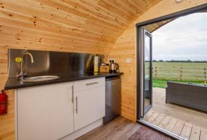 eine Küche in einem winzigen Haus mit einem großen Fenster in der Unterkunft Little Meadow Pods with Hot Tub in York