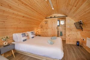 ein Schlafzimmer mit einem Bett in einem Blockhaus in der Unterkunft Little Meadow Pods with Hot Tub in York