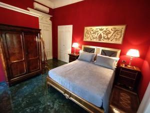 - une chambre aux murs rouges et un lit avec deux lampes dans l'établissement NOBILI LIBARDI - VILLA BASEVI, à Vérone