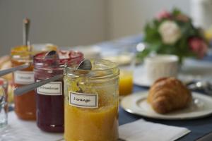 a table with a jar of jam and a plate of food at Villa du Square, Luxury Guest House in Paris