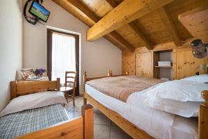 een slaapkamer met een bed, een bureau en een televisie bij Hotel Gallo Cedrone in Valdisotto