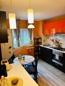 een keuken met oranje kasten en een tafel en stoelen bij Euro Apartment in Boekarest