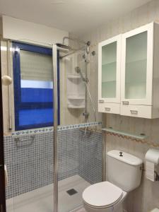 uma casa de banho com um WC e uma cabina de duche em vidro. em Punta Umbría relax em Punta Umbría