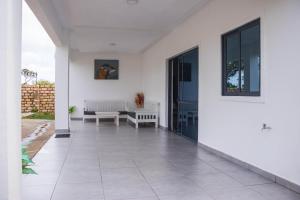 um alpendre vazio de uma casa branca com um banco em 4 U Luxury Bungalows Diani em Praia de Diani