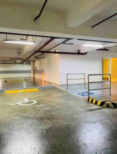 an empty parking garage with a parking lot sign on the floor at SMDC Wind: T2 La Maison du Basa in Tagaytay