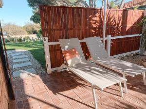 two lawn chairs sitting next to a fence at BEACH 400m, Big Yard, Playroom, Perfect for Families, Couples, Digital Nomads in Mandurah