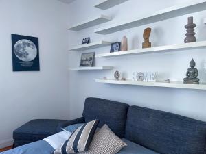 a living room with a blue couch and shelves at Domus Montebello in Rome