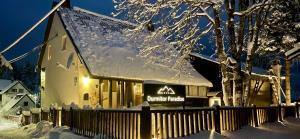 un edificio con un cartel en la nieve en Guest House Durmitor Paradise, en Žabljak