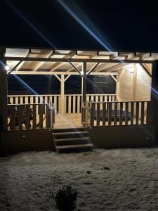 un pabellón de madera con escaleras y luces por la noche en Hirska Vatra, en Slavske