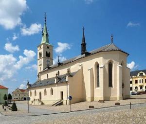 ein großes Gebäude mit einem Uhrturm darüber in der Unterkunft Ubytování v centru Kašperských Hor in Kašperské Hory