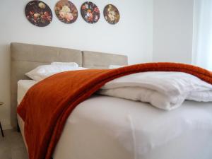 Una cama con una manta en ella con platos en la pared en AMAO-Brown I 85qm I Central Location I King-Size Bed I Private Parking I Near Storchenturm, en Lahr