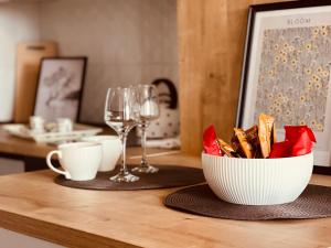 una mesa con un tazón de aperitivos y copas de vino en Ski INN apartment Jahorina, en Jahorina