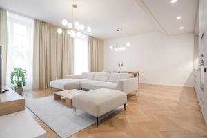 ein Wohnzimmer mit weißen Möbeln und Holzböden in der Unterkunft Laurinska 1 Apartments in Bratislava