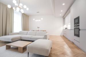 ein weißes Wohnzimmer mit einem Sofa und einem Tisch in der Unterkunft Laurinska 1 Apartments in Bratislava