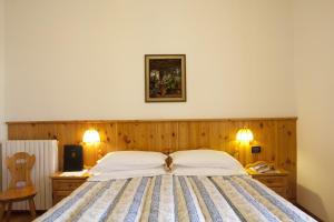 מיטה או מיטות בחדר ב-Hotel Bellaria - Cortina d'Ampezzo