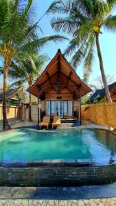 ein Haus mit einem Pool und Palmen in der Unterkunft Beach House Penida in Nusa Penida