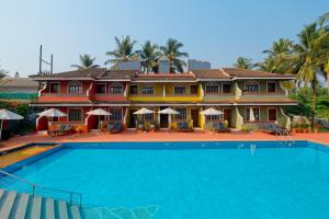 une grande maison avec une piscine en face de celle-ci dans l'établissement Skylark Resort, à Colva