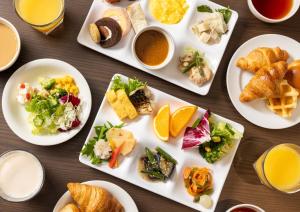 una mesa cubierta con platos de comida y bebida en ibis Budget Osaka Umeda, en Osaka