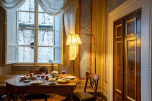 een eetkamer met een tafel en een raam bij Palazzo Rocchi - Residenza D'Epoca in Lucca