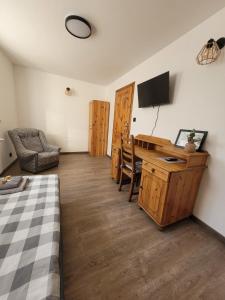 a bedroom with a desk and a bed and a television at Gościniec Błogocice in Cieszyn