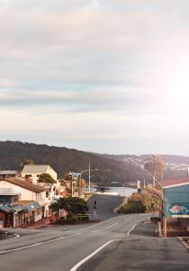 an empty street in a small town next to a river at Holiday Lodge Motor Inn in Narooma