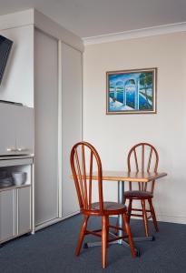 a dining room with a table and two chairs at Holiday Lodge Motor Inn in Narooma