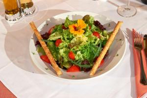 ein weißer Teller mit Salat auf dem Tisch in der Unterkunft Alpenhof Annaberg in Annaberg im Lammertal