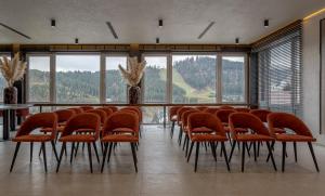 une salle de conférence avec des chaises orange et une table dans l'établissement Didukh Eco Hotel&Spa, à Bukovel