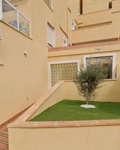 une maison avec un arbre sur son côté dans l'établissement Apartamento Catania en Aguadulce con vistas al mar, à Aguadulce