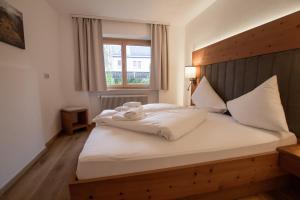 una camera con letto con testiera in legno e finestra di Hochtenn Lodge in Zell am See - Steinbock Lodges a Zell am See