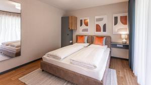 1 dormitorio con 1 cama grande y espejo en KULA Comfort Rooms, en Villach