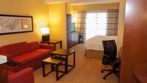 um quarto de hotel com um sofá e uma cama em Courtyard by Marriott Pittsburgh North/Cranberry Woods em Cranberry Township