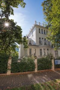 un edificio blanco con árboles delante de él en Apartments Villa Whitehouse, en Ostrava