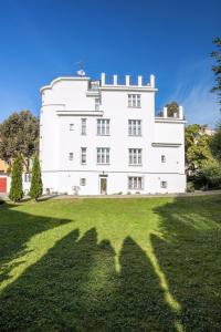 un gran edificio blanco en un campo de hierba en Apartments Villa Whitehouse, en Ostrava