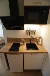 A kitchen or kitchenette at Le Golden-Terrasse & Parking