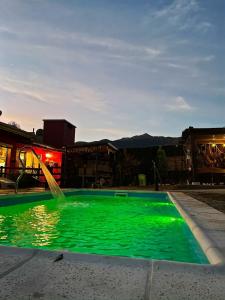 une piscine verdoyante avec une fontaine dans l'établissement Apart del Valle, à Tafí del Valle