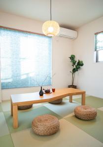 - un salon avec une table en bois et des tabourets dans l'établissement 大吉屋日赤館貸切一軒家旅館新築名古屋駅圏内, à Nagoya