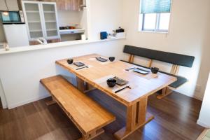 - une table à manger et un banc dans une pièce dans l'établissement 大吉屋日赤館貸切一軒家旅館新築名古屋駅圏内, à Nagoya