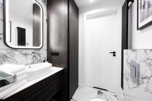 a bathroom with a sink and a mirror at Native Apartments Kościuszki 39 in Kraków