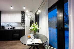 a kitchen with a table with a vase on it at Native Apartments Kościuszki 39 in Kraków