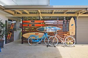 two bikes parked in a garage next to surfboards at Motel Sunshine Coast in Caloundra