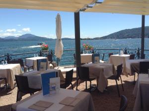 a restaurant with tables and a view of the water at Hotel Eden in Baveno