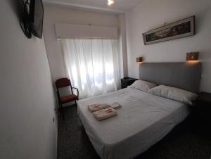 a bedroom with a bed with two towels on it at Hotel eden in Bahía Blanca